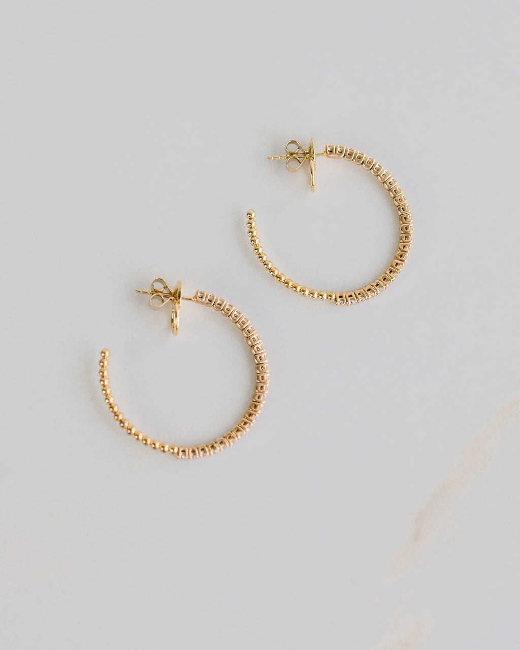 Gold hoop earrings on a light gray background
