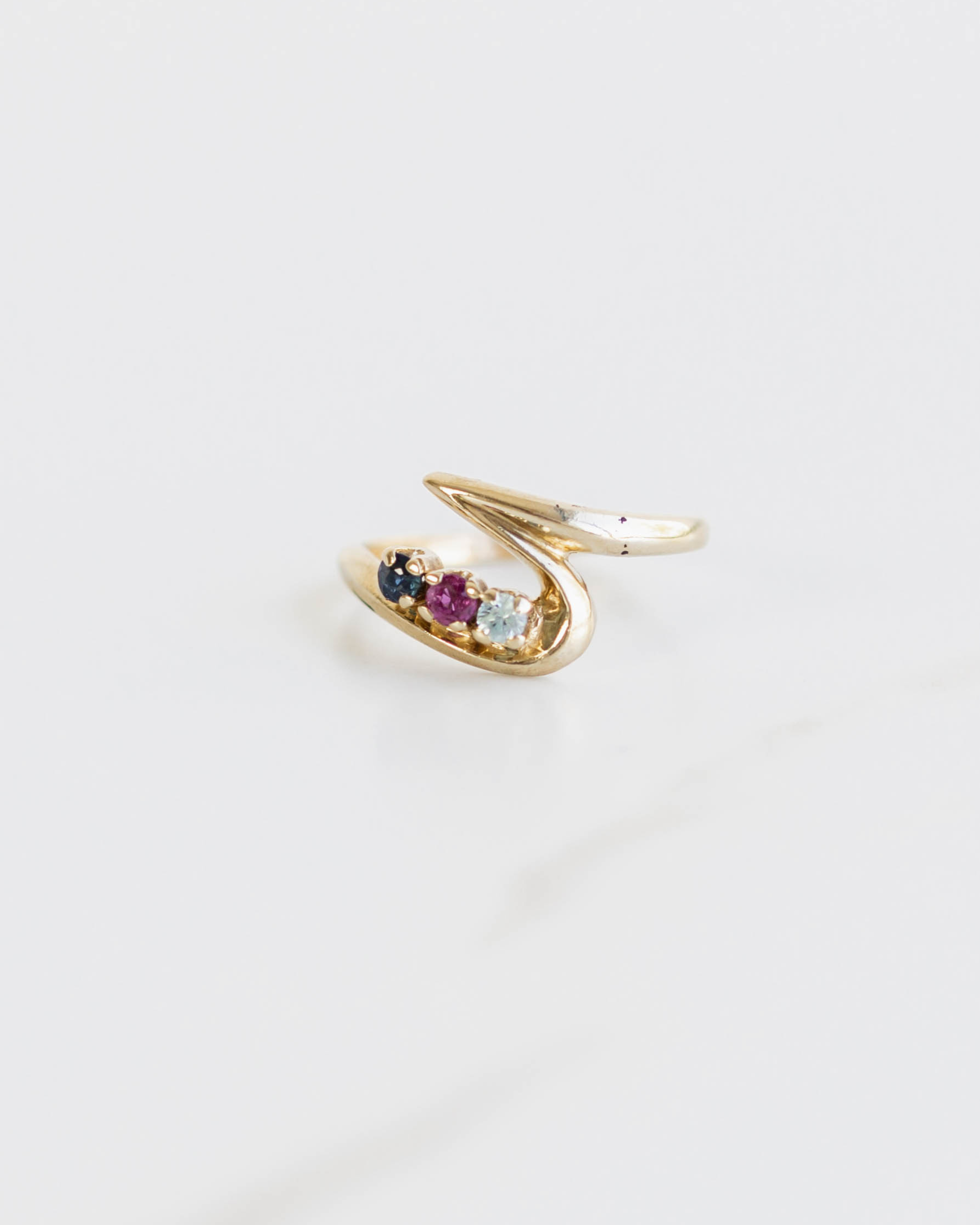 Gold ring with embedded gemstones on a white background