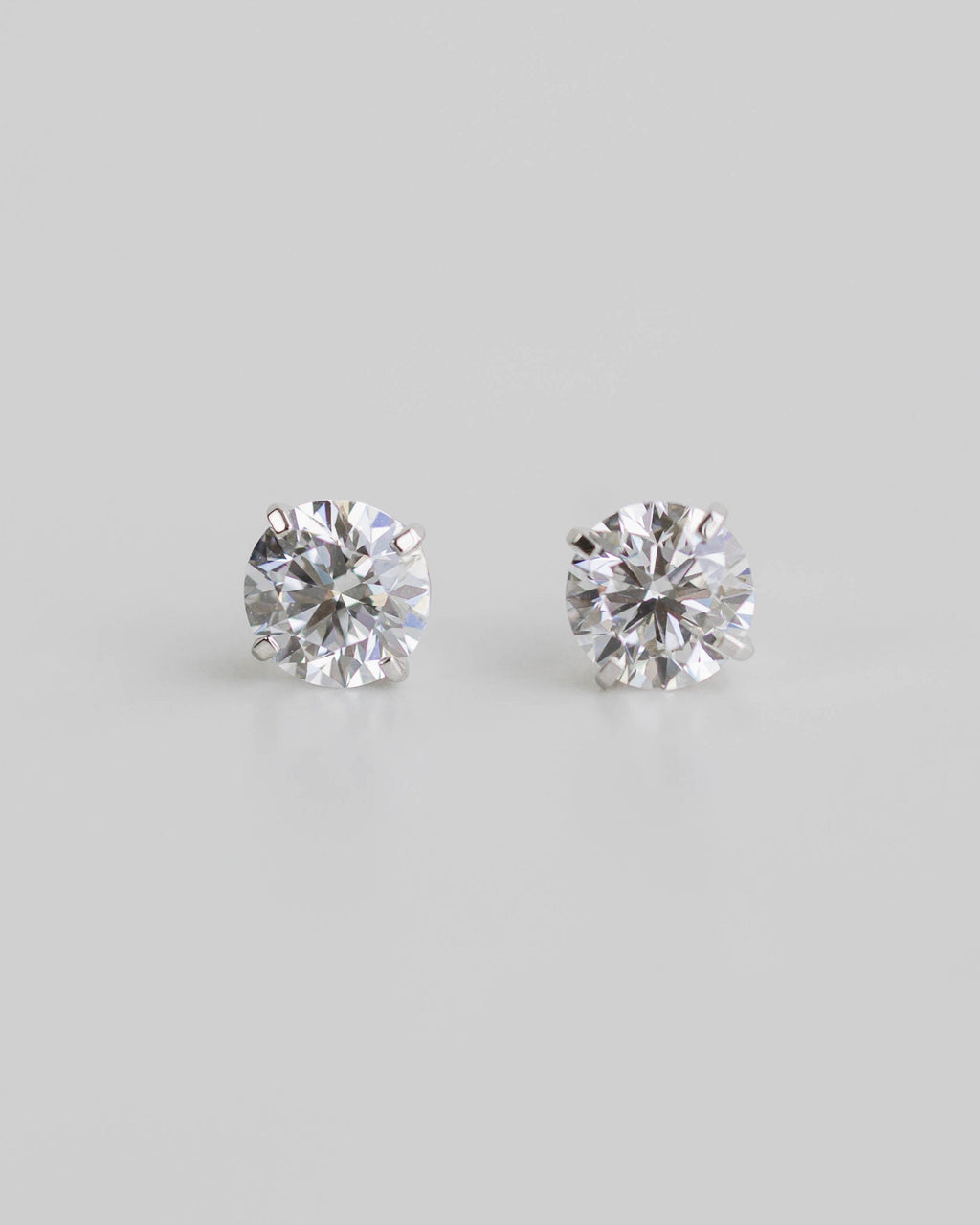 Pair of diamond stud earrings on a light gray background