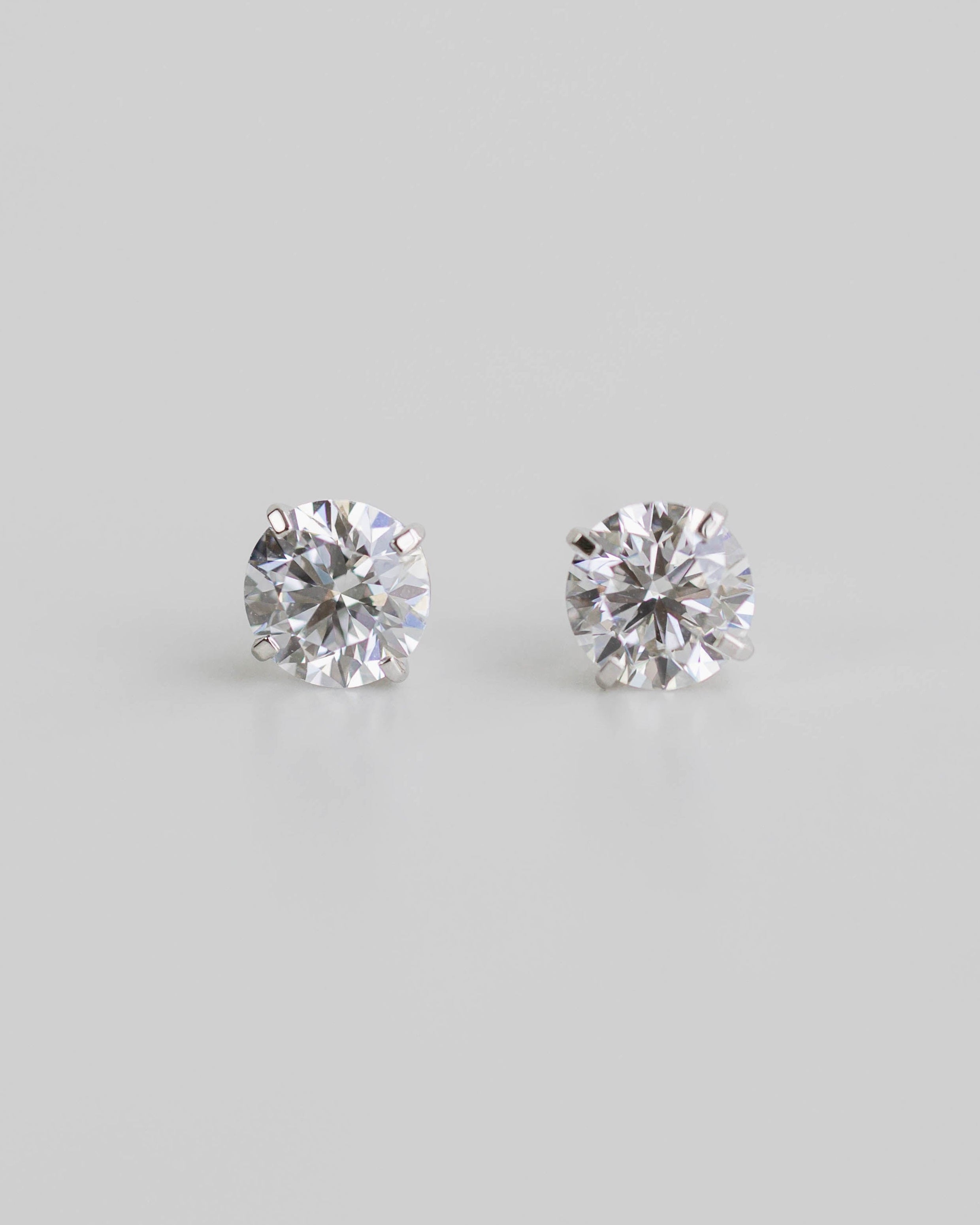 Pair of diamond stud earrings on a light gray background