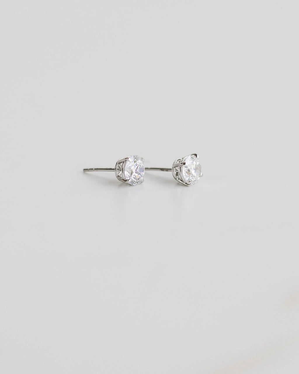 Pair of silver stud earrings on a light gray background