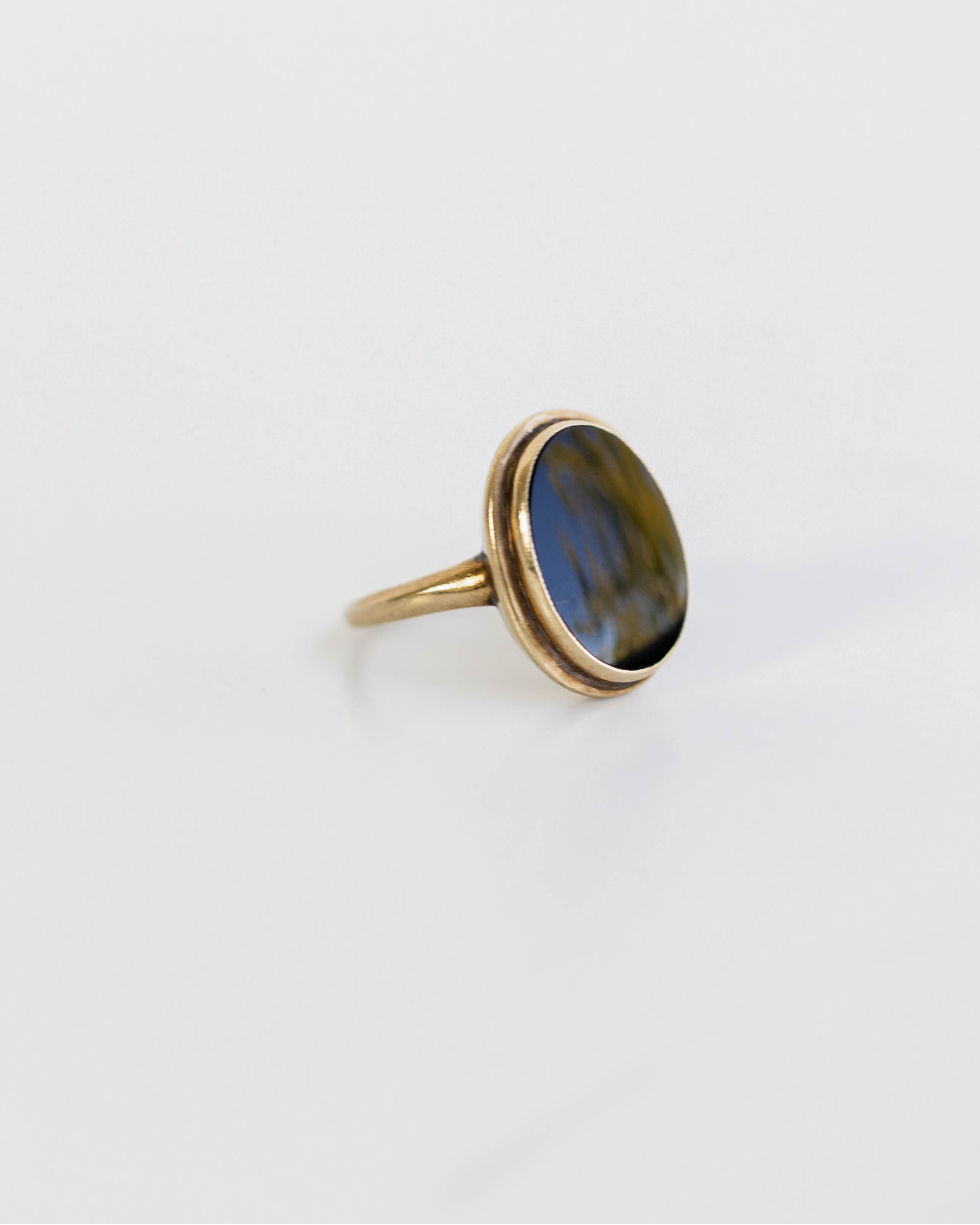 Gold ring with a blue stone on a white background