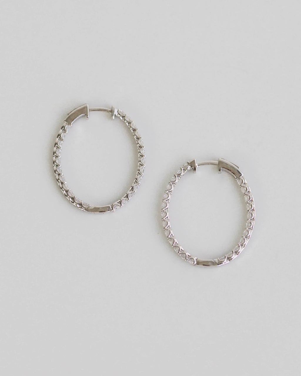 Pair of silver hoop earrings on a light gray background