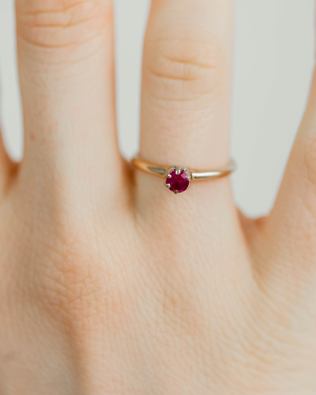 Gold ring with diamond accents on a light gray background