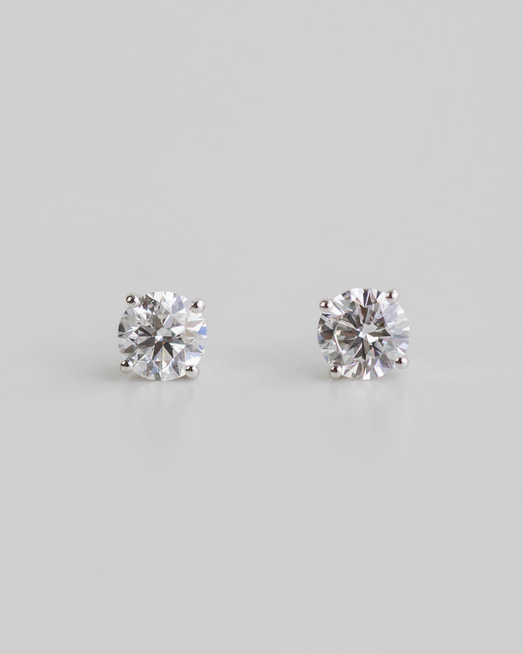 Pair of diamond stud earrings on a light gray background
