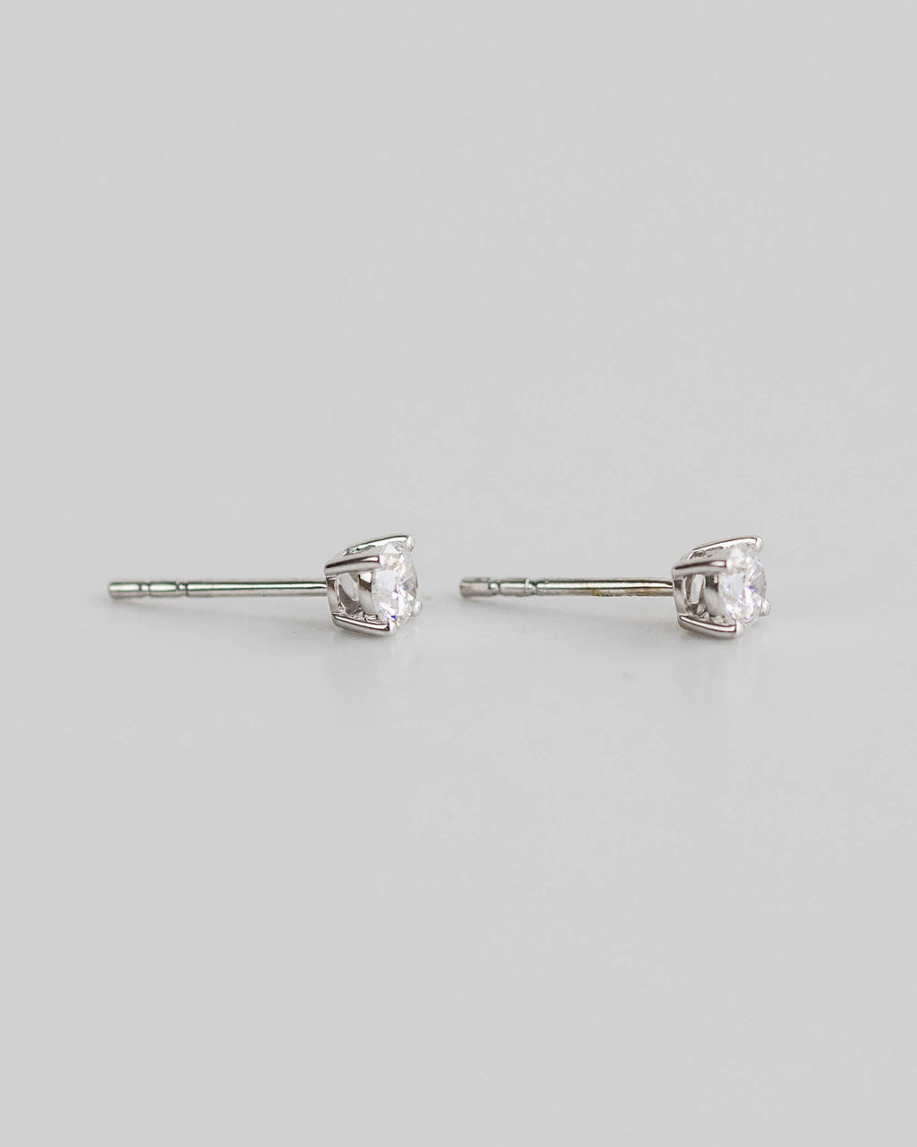 Pair of silver stud earrings on a light gray background