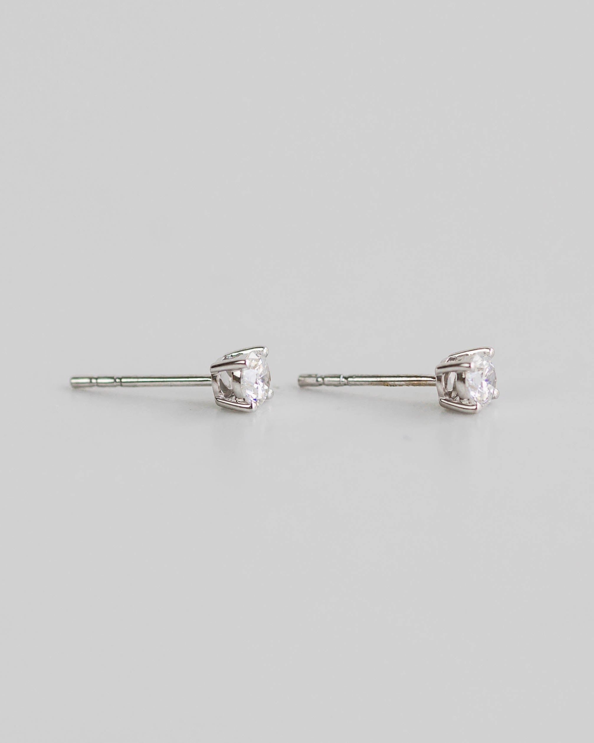 Pair of silver stud earrings on a light gray background