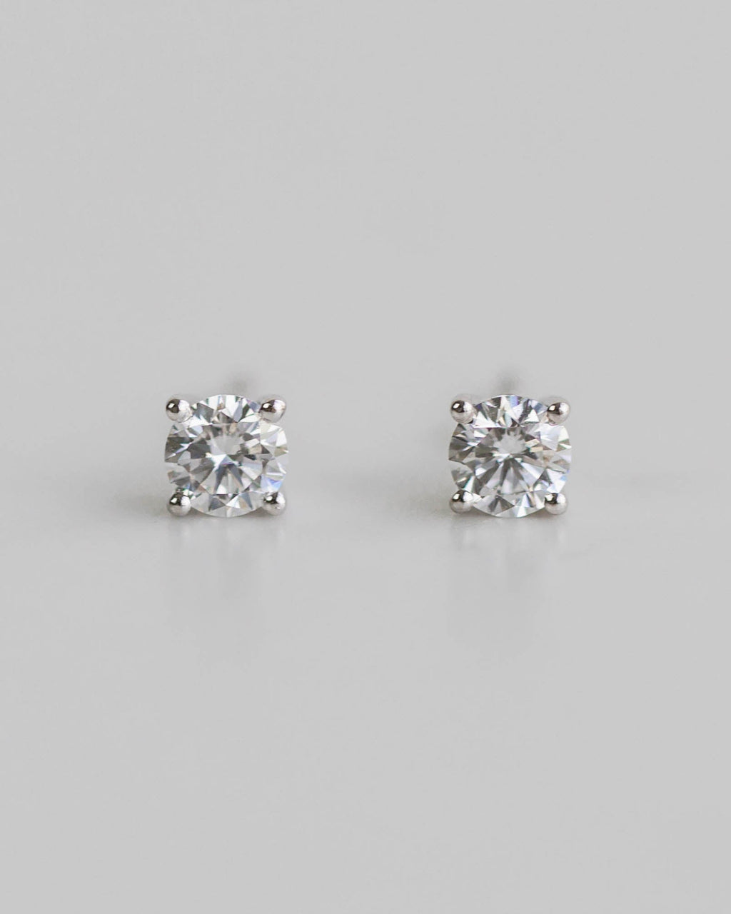 Pair of diamond stud earrings on a light gray background