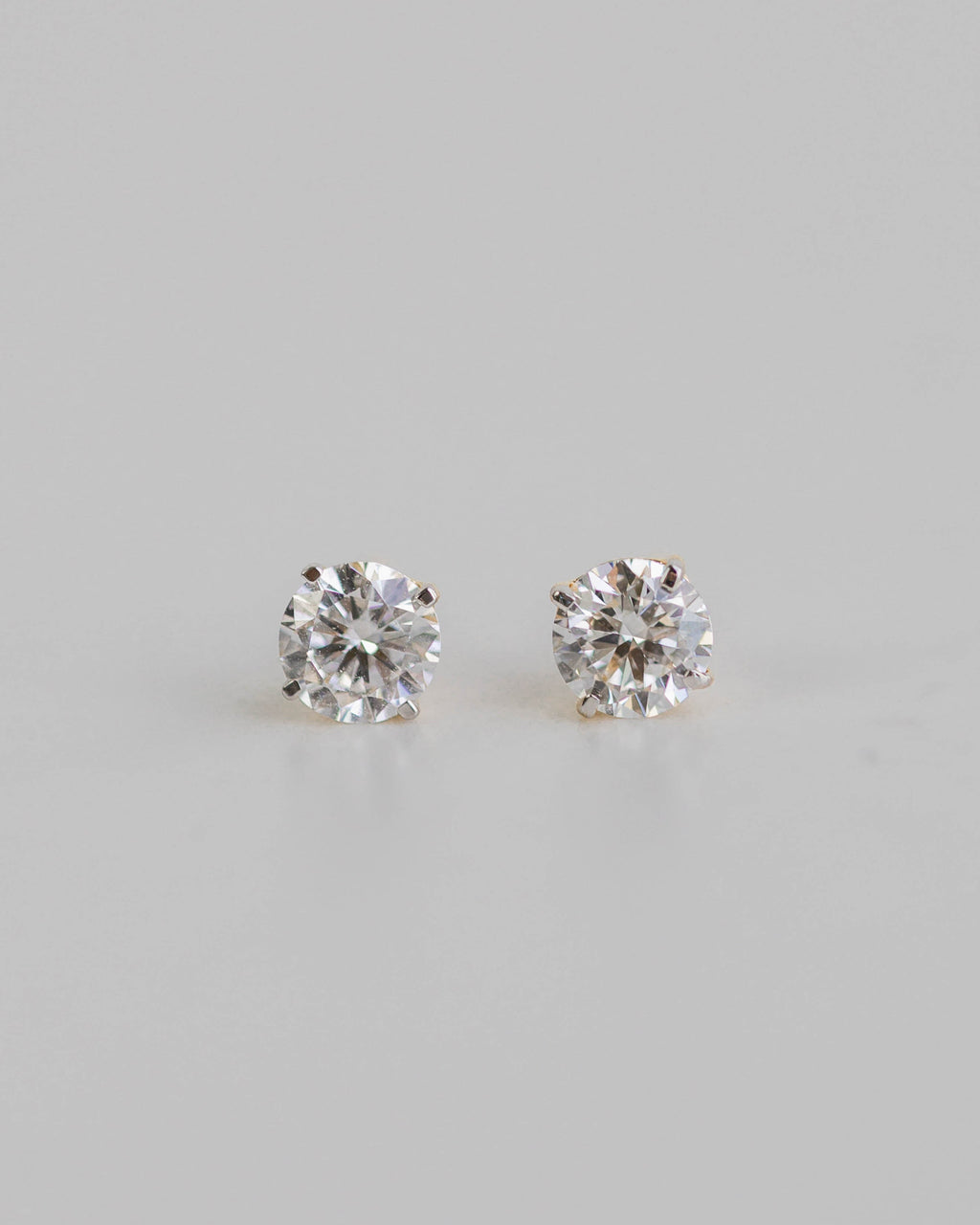 Pair of diamond stud earrings on a light gray background