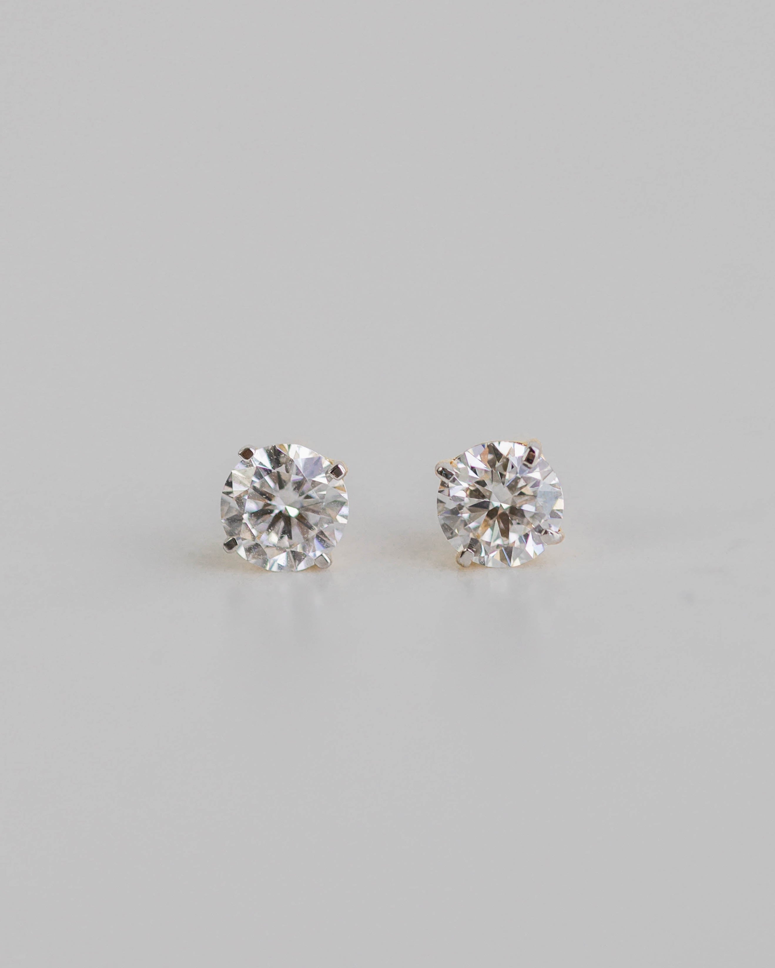 Pair of diamond stud earrings on a light gray background