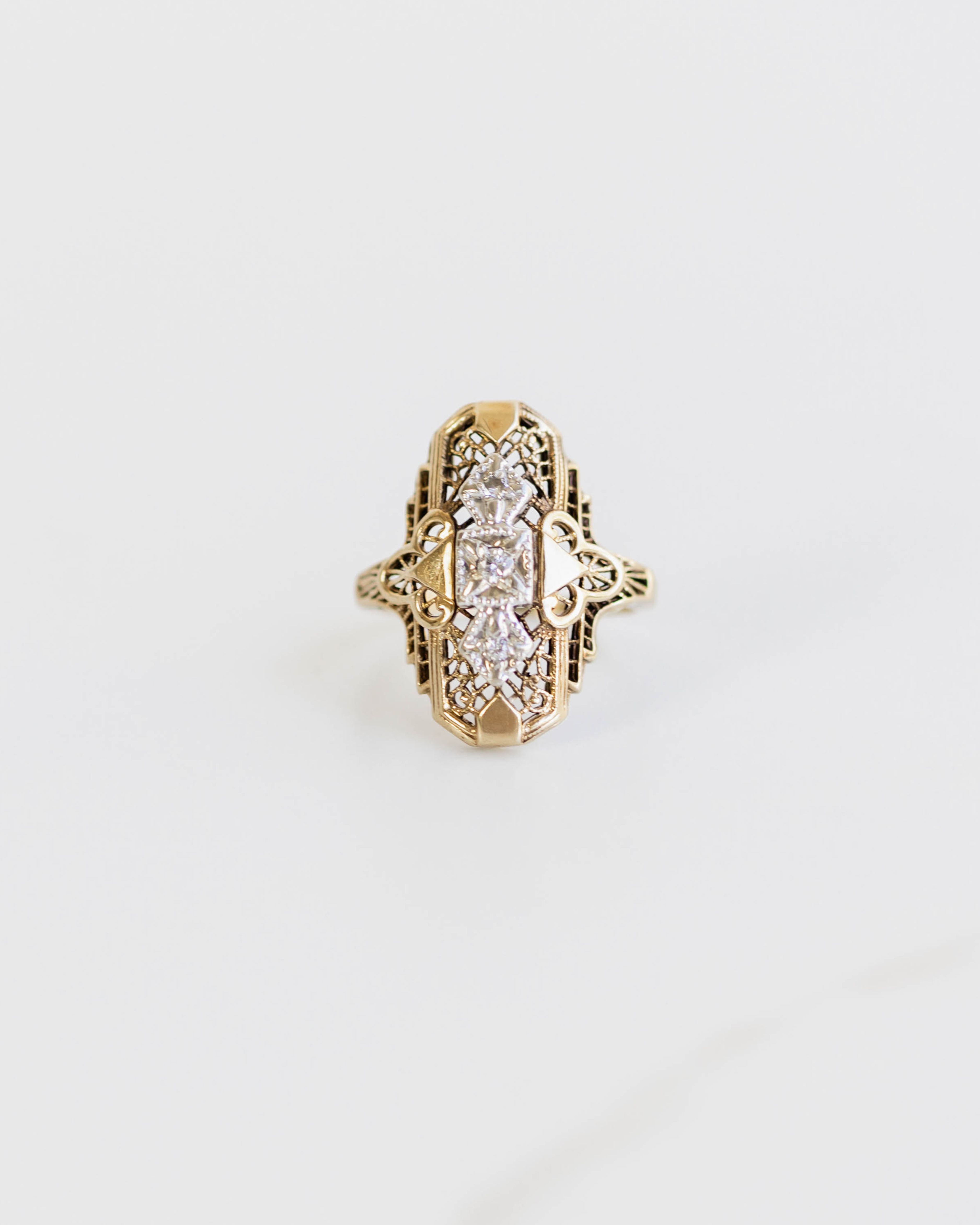Gold ring with a diamond on a light gray background